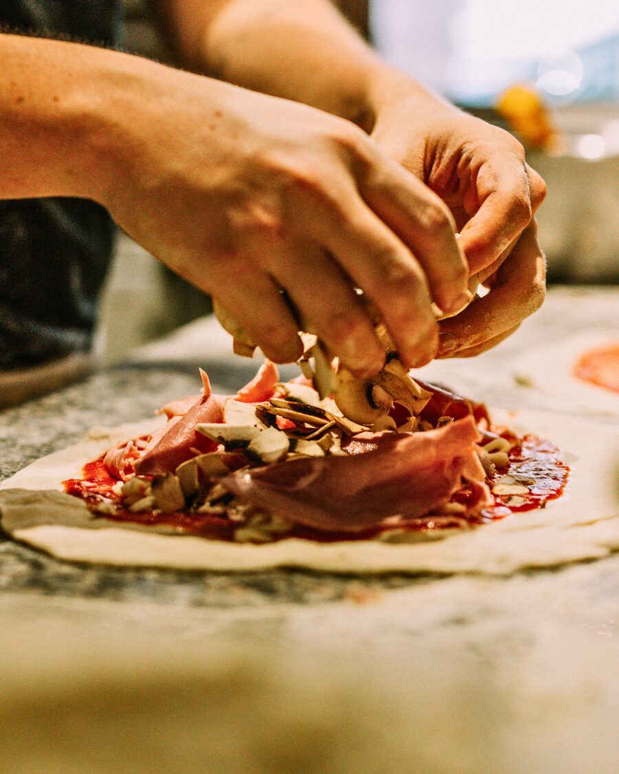 Préparation artisanale d’une pizza à la Trattoria Bella