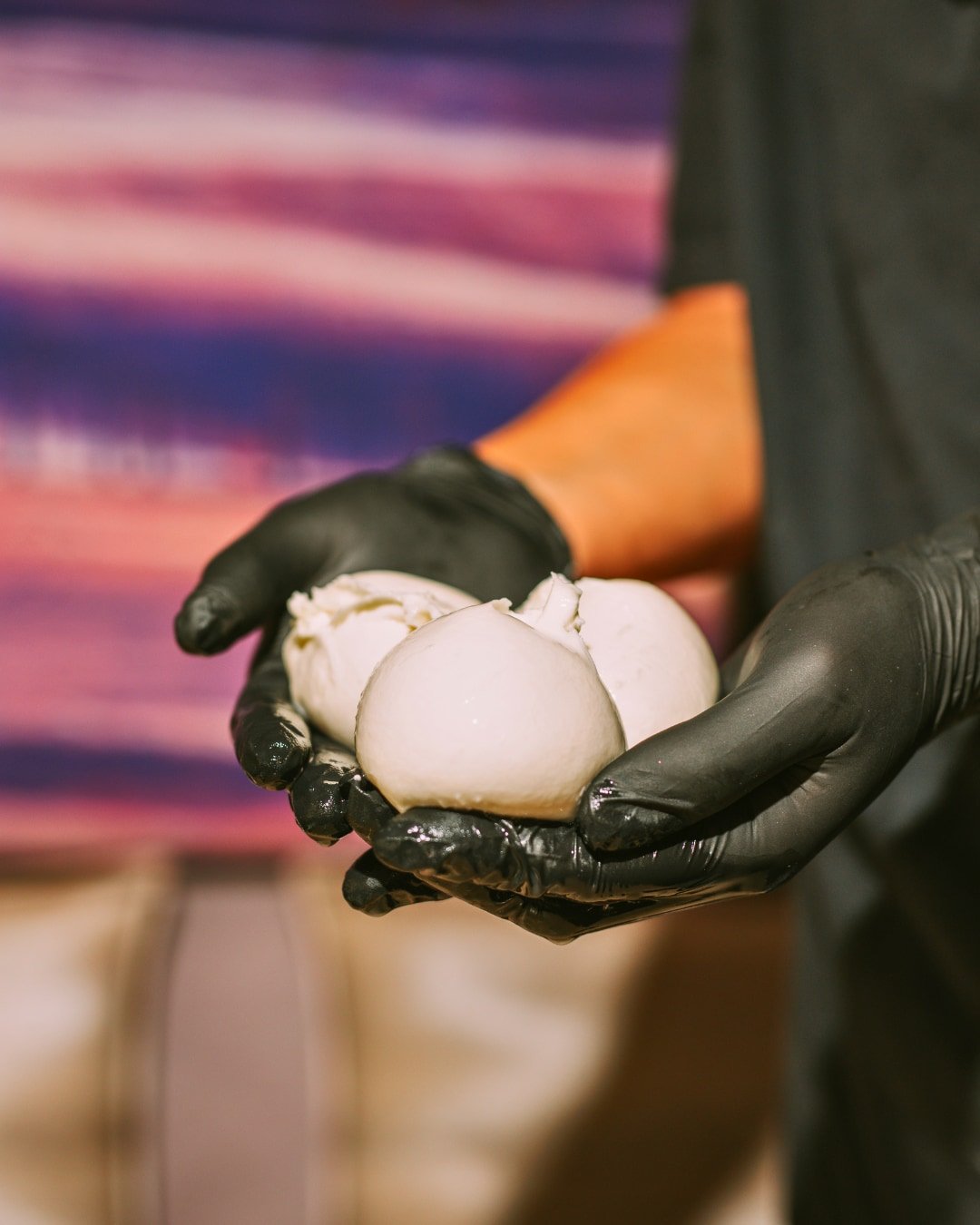 Mozzarella ouverte et présentée entre les mains en cuisine à la Trattoria Bella
