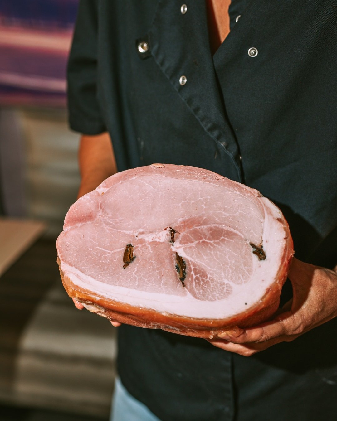 Pièce de jambon présentée en cuisine à la Trattoria Bella